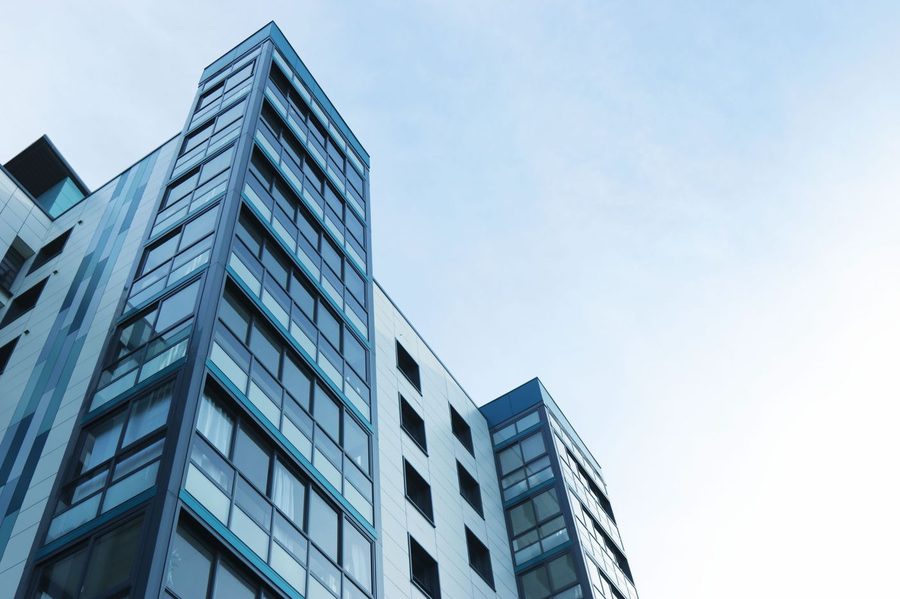 Modern glass-and-steel commercial building against a clear sky